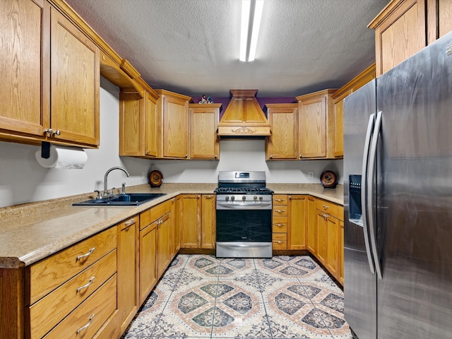 kitchen featuring appliances with stainless steel finishes, sink, a textured ceiling, and premium range hood