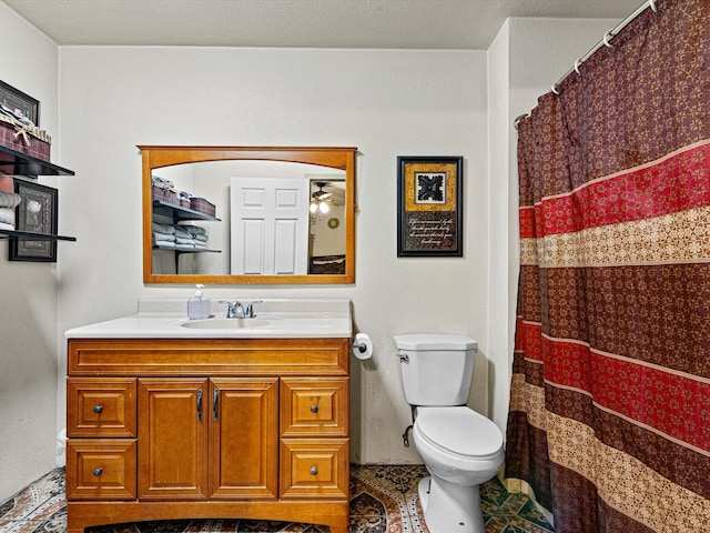 bathroom featuring ceiling fan, vanity, toilet, and tile patterned flooring