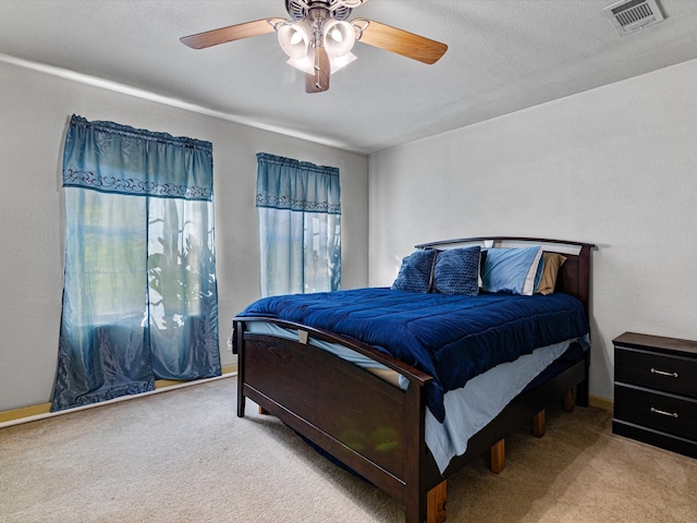 carpeted bedroom featuring a textured ceiling and ceiling fan