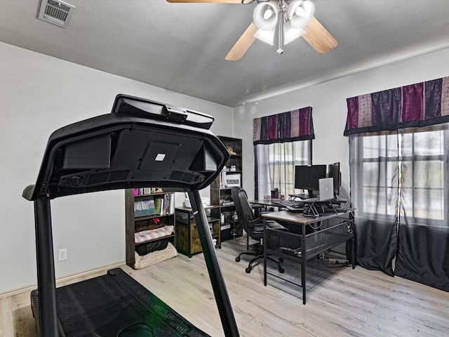 office area with ceiling fan, light wood-type flooring, and a textured ceiling