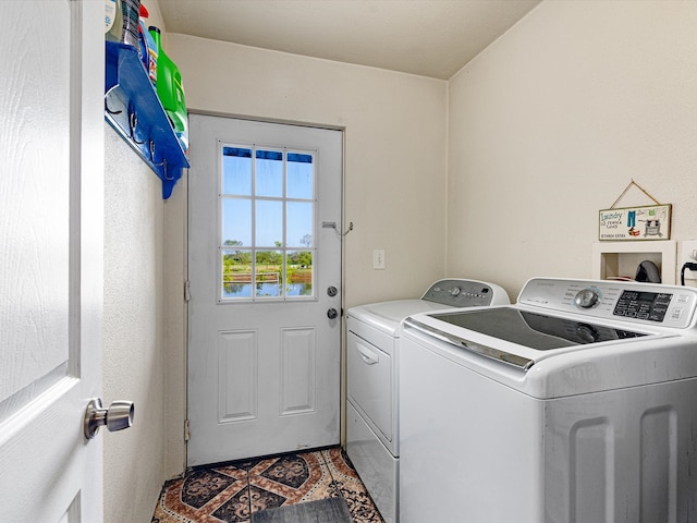 laundry area featuring washing machine and clothes dryer and light tile patterned floors