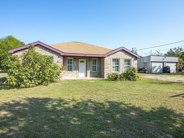 view of front facade with an outbuilding, a front lawn, and a garage