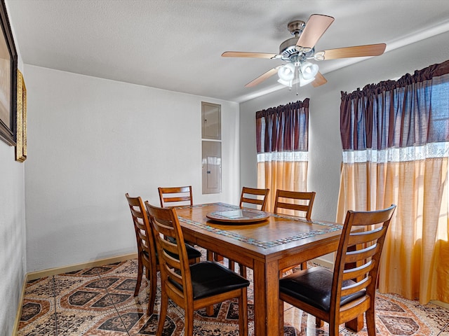 dining room featuring ceiling fan and a textured ceiling