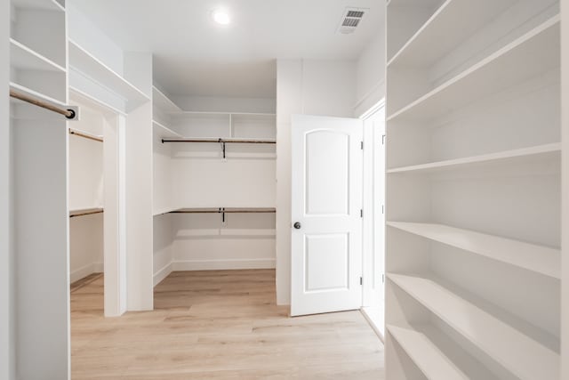 spacious closet with light hardwood / wood-style flooring