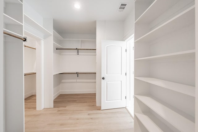 spacious closet with light wood-style floors and visible vents