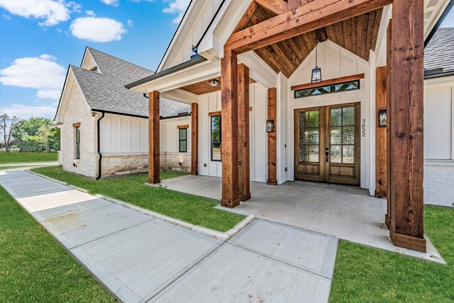 view of exterior entry with french doors and a yard