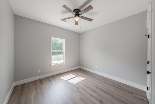 unfurnished room featuring light wood-type flooring, ceiling fan, visible vents, and baseboards