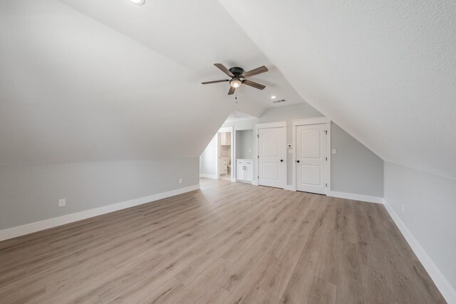 additional living space with light hardwood / wood-style flooring, lofted ceiling, and ceiling fan