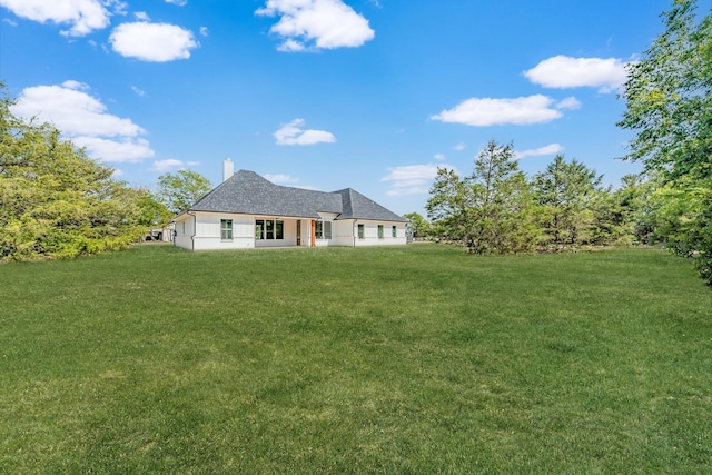 view of front of home with a chimney and a front yard