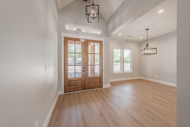 entrance foyer with baseboards, light wood finished floors, and a notable chandelier