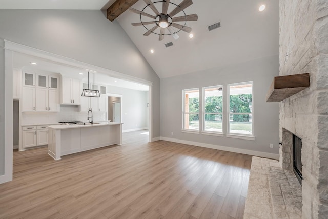 kitchen with visible vents, white cabinets, glass insert cabinets, decorative light fixtures, and light countertops