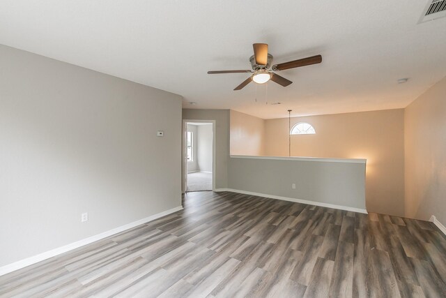 spare room featuring ceiling fan, wood-type flooring, and a healthy amount of sunlight