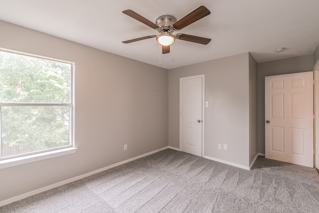 unfurnished bedroom featuring ceiling fan, carpet flooring, and multiple windows