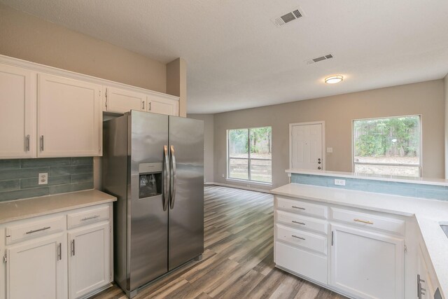 kitchen featuring tasteful backsplash, stainless steel refrigerator with ice dispenser, light hardwood / wood-style flooring, and white cabinetry