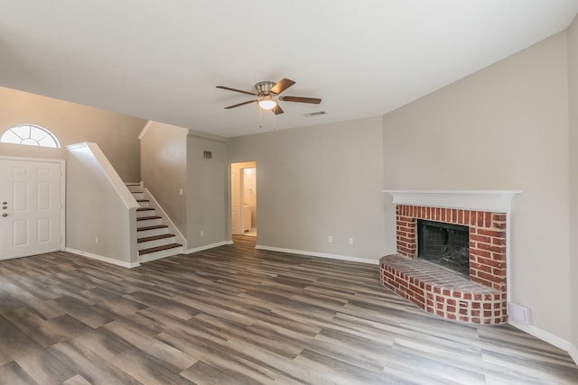 unfurnished living room featuring hardwood / wood-style floors, a brick fireplace, and ceiling fan