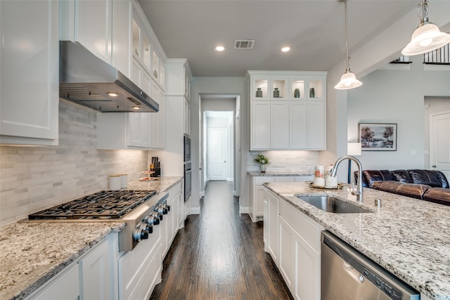 kitchen featuring stainless steel appliances, sink, tasteful backsplash, white cabinetry, and wall chimney range hood