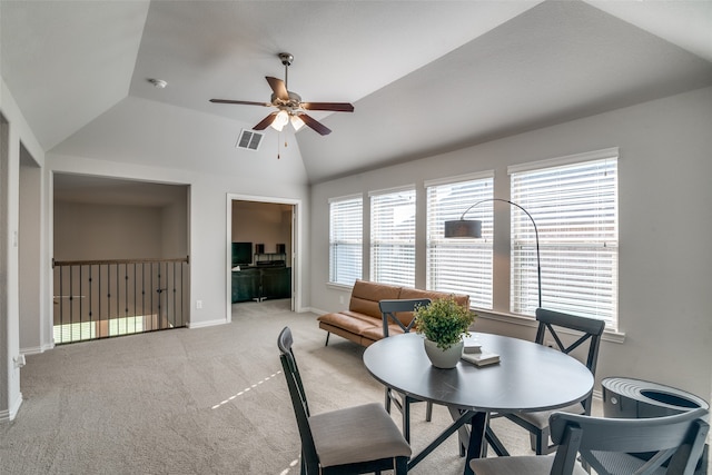 dining space featuring ceiling fan, vaulted ceiling, and light colored carpet