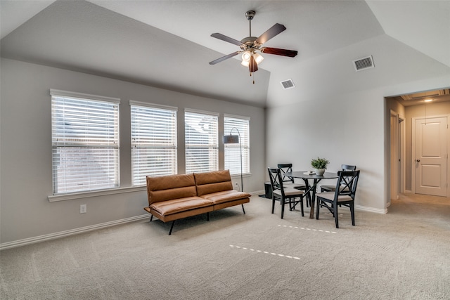 living area with ceiling fan, lofted ceiling, and light colored carpet