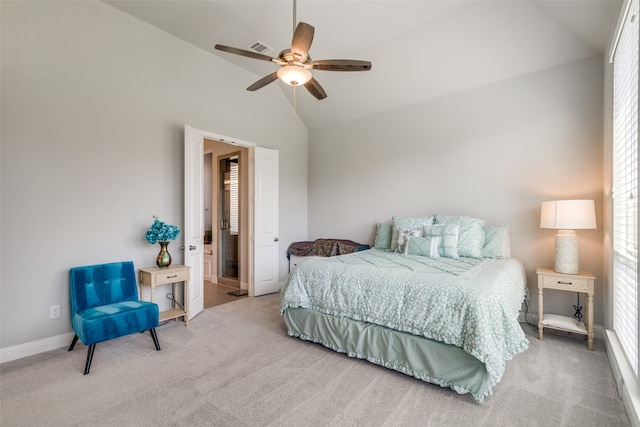 carpeted bedroom with ceiling fan and high vaulted ceiling