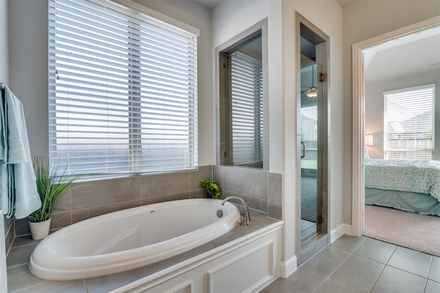 bathroom with a tub to relax in and tile patterned floors