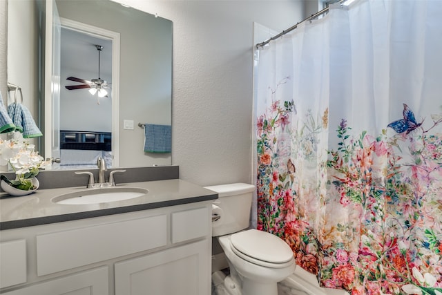 bathroom featuring toilet, vanity, and ceiling fan