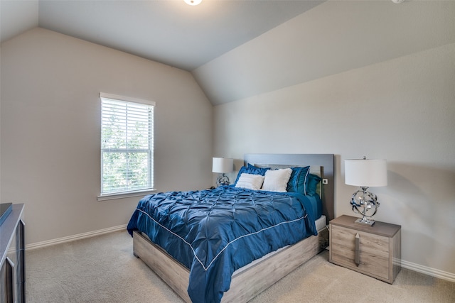 bedroom with lofted ceiling and light carpet