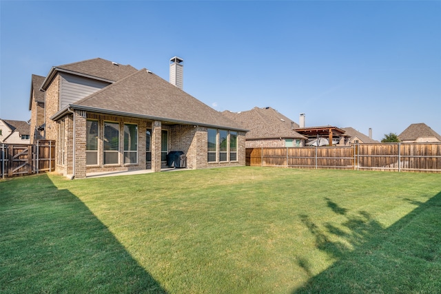 back of house with a patio area and a yard