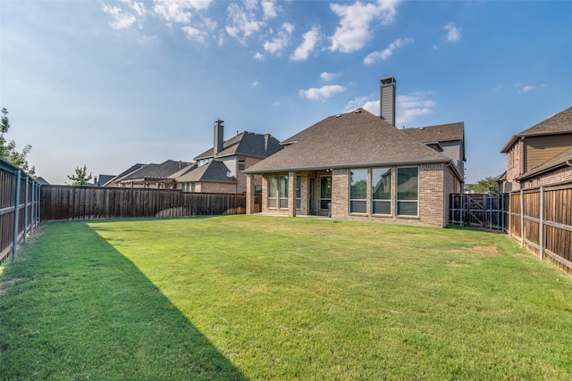 rear view of property with a lawn