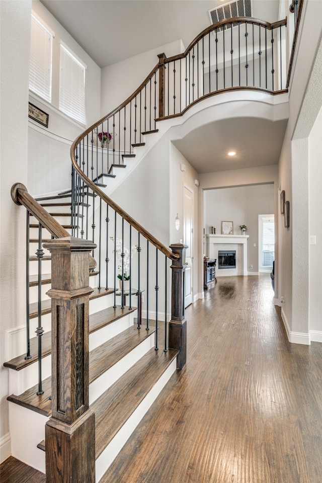 staircase featuring a high ceiling and hardwood / wood-style floors