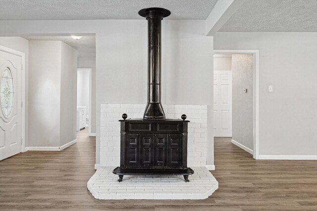 2120 Nottingham Blvd, Fort Worth, TX 76112 - room details with hardwood / wood-style flooring, a textured ceiling, and a wood stove