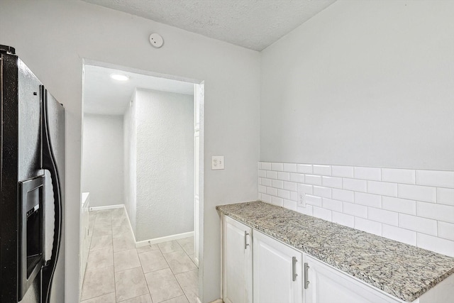 2120 Nottingham Blvd, Fort Worth, TX 76112 - kitchen featuring white cabinetry, light tile patterned floors, stainless steel fridge with ice dispenser, light stone countertops, and a textured ceiling