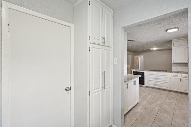 2120 Nottingham Blvd, Fort Worth, TX 76112 - kitchen featuring white cabinetry, light stone counters, tasteful backsplash, a textured ceiling, and black electric cooktop