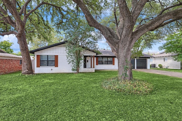 ranch-style home featuring a garage and a front lawn