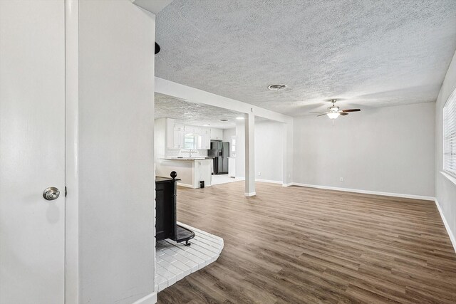 2120 Nottingham Blvd, Fort Worth, TX 76112 - living room with a healthy amount of sunlight, ceiling fan, wood-type flooring, and a textured ceiling