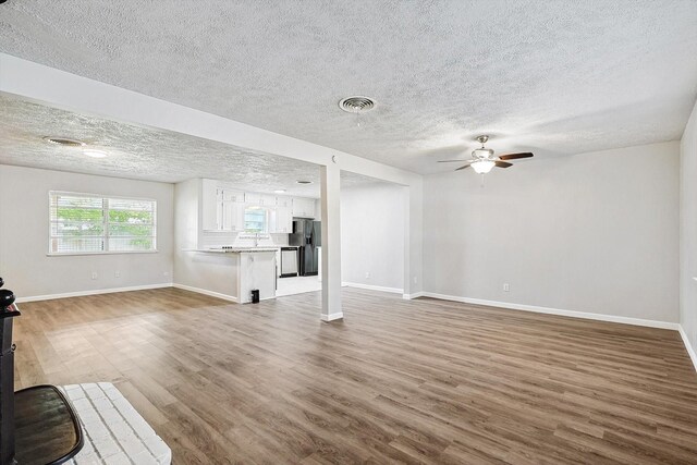 2120 Nottingham Blvd, Fort Worth, TX 76112 - unfurnished living room with hardwood / wood-style flooring, a textured ceiling, and ceiling fan
