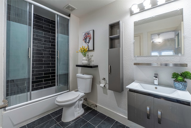 full bathroom featuring shower / bath combination with glass door, vanity, toilet, and tile patterned floors