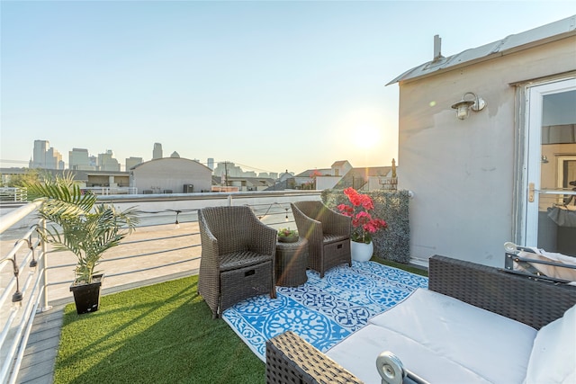 patio terrace at dusk featuring a lawn and a balcony