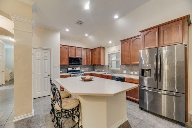 kitchen with a breakfast bar, sink, crown molding, a center island, and black appliances