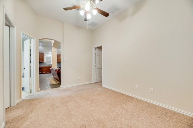 tiled empty room with ceiling fan and a high ceiling