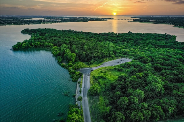 aerial view at dusk featuring a water view