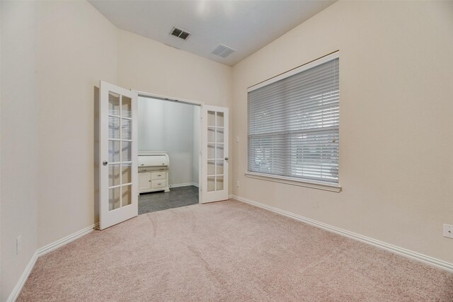 unfurnished bedroom featuring french doors and carpet