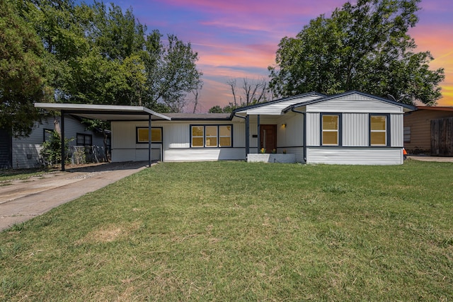 single story home featuring a carport and a lawn