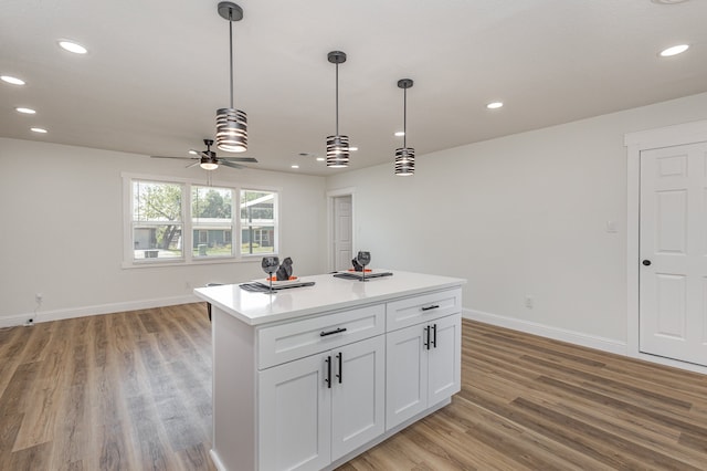 kitchen with ceiling fan, light wood-type flooring, decorative light fixtures, and white cabinets