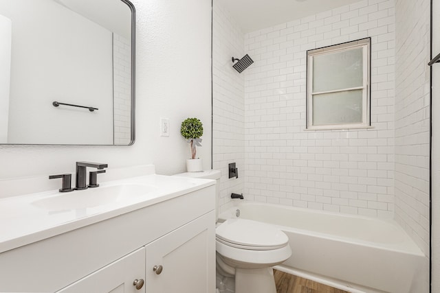 full bathroom featuring vanity, tiled shower / bath combo, toilet, and hardwood / wood-style floors