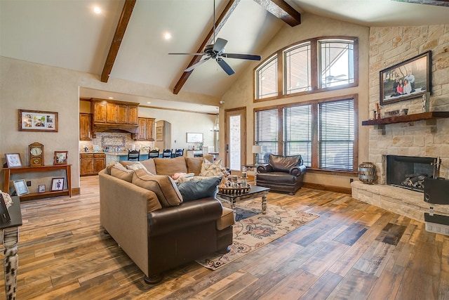 living room with ceiling fan, high vaulted ceiling, a fireplace, and hardwood / wood-style floors