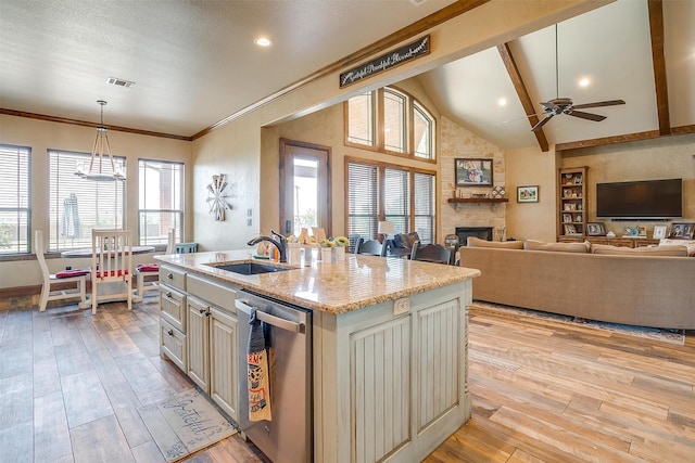 kitchen featuring stainless steel dishwasher, a center island with sink, light hardwood / wood-style floors, vaulted ceiling with beams, and sink