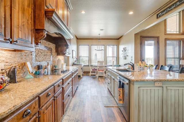 kitchen featuring tasteful backsplash, an island with sink, ornamental molding, and plenty of natural light