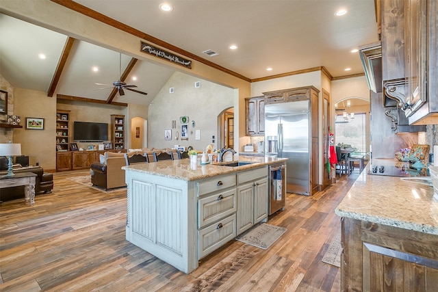 kitchen featuring ceiling fan, wood-type flooring, sink, and an island with sink