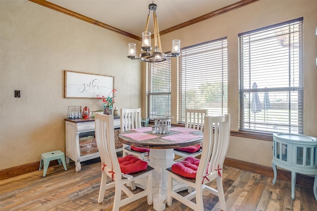 dining room featuring a chandelier, a healthy amount of sunlight, hardwood / wood-style floors, and crown molding