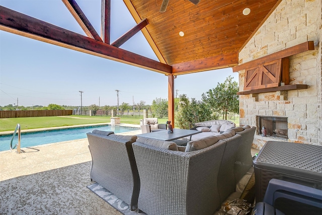 view of patio / terrace featuring a fenced in pool and an outdoor living space with a fireplace